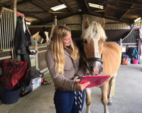 A woman standing near to horse